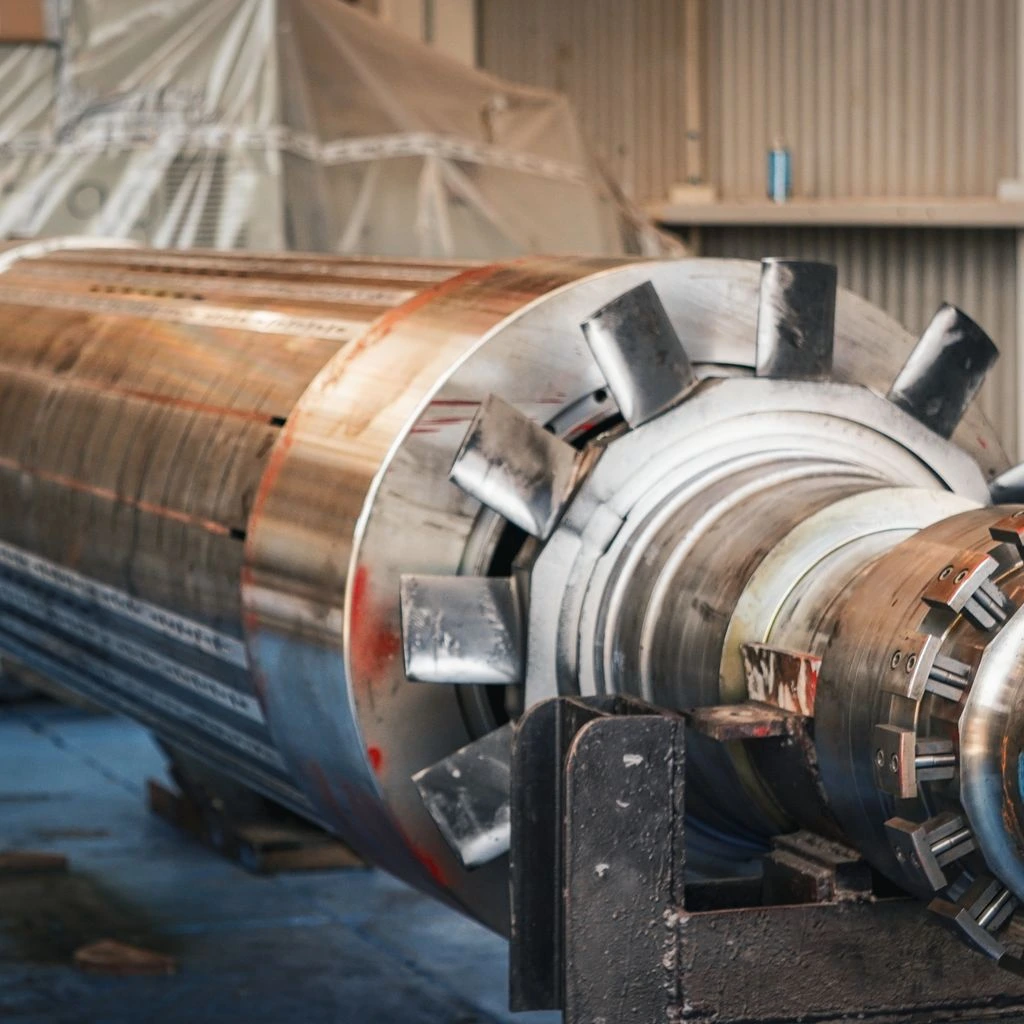 Trunnion-mounted carbon steel ball valve with orange-highlighted machined surfaces, photographed against a dark technical background